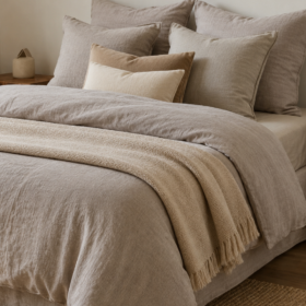 Letto matrimoniale con biancheria in lino nei toni beige, tortora e greige